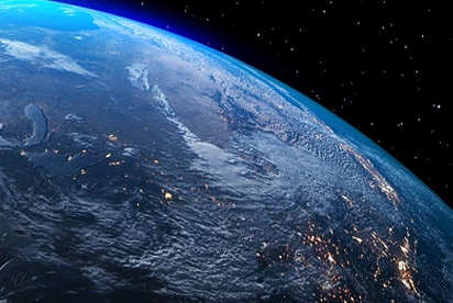 Image of Earth from space showing illuminated continents at night.